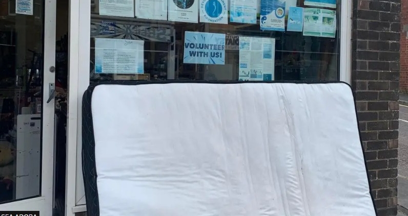 Image of fly tipped mattress outside charity shop